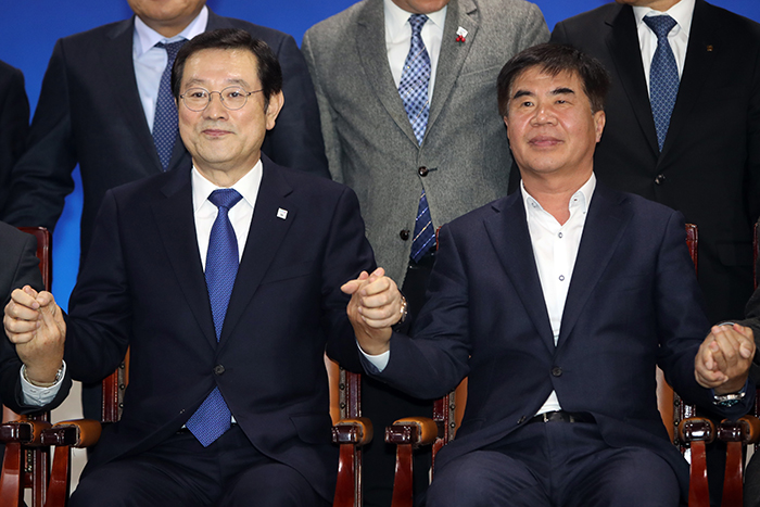 Gwangju Mayor Lee Yong-Seop (left) and Federation of Korean Trade Unions President Yoon Jong-hae on Dec. 5 hold hands after concluding their meeting at Gwangju City Hall. (Yonhap News)
